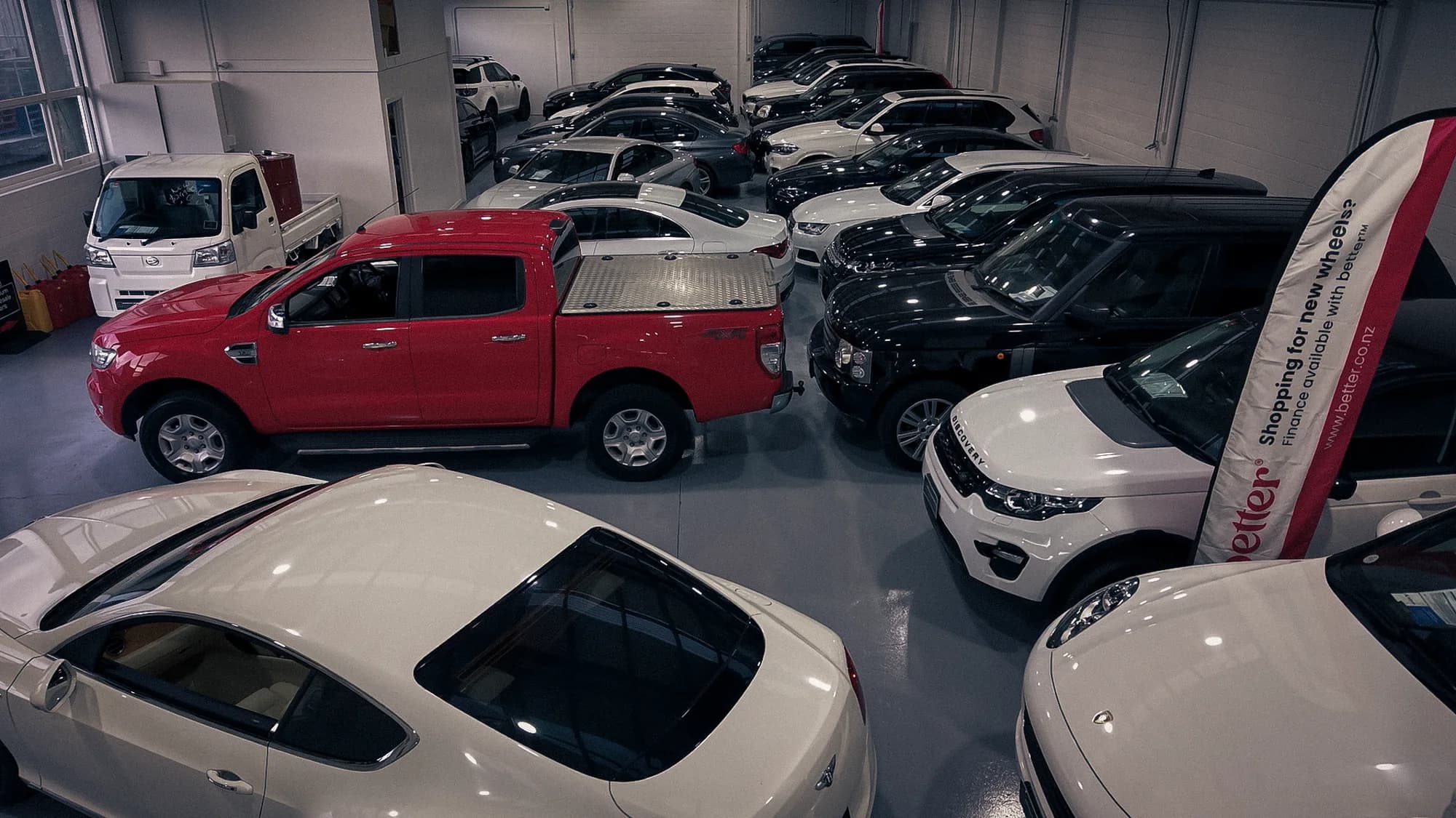 Ute, SUVs and sedans packed tightly inside the Auto Luxe indoor showroom