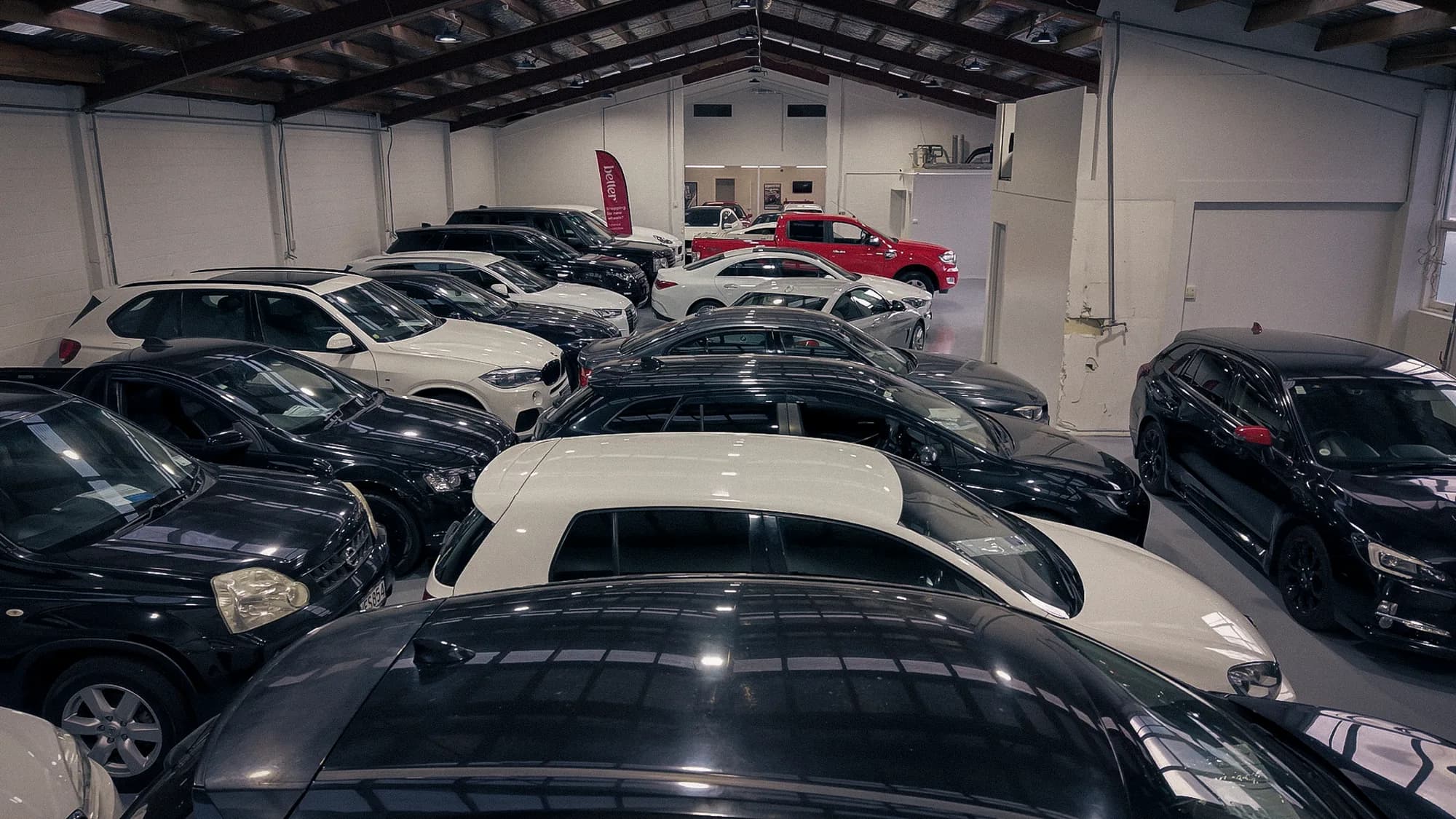 Range of vehicles displayed under the vaulted showroom roof at Auto Luxe Sockburn